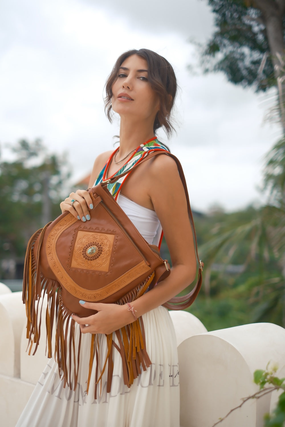 Artisan crossbody bag with long tan fringe, adjustable strap, and spacious interior — Goldie Horizon by House of Hide.