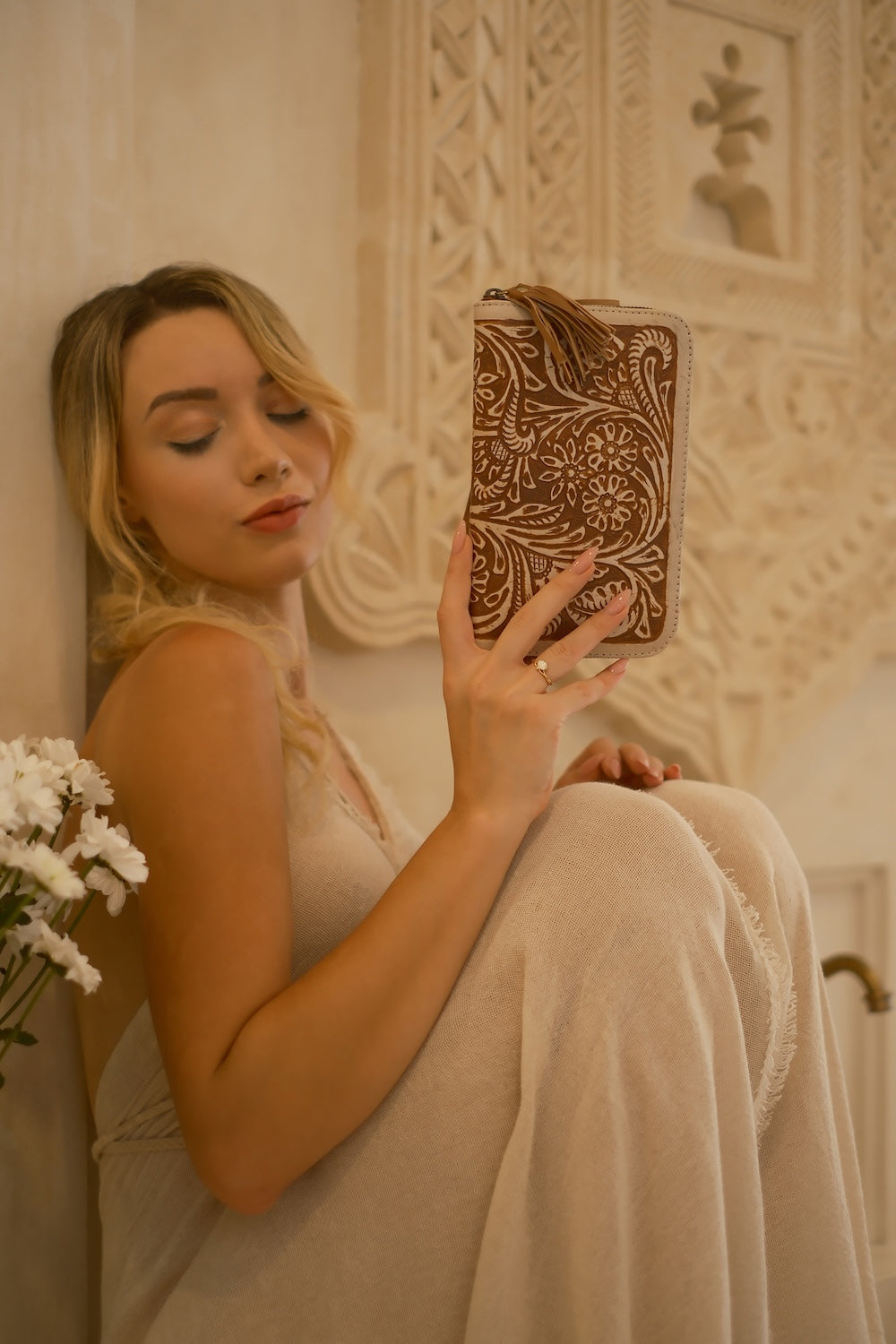 Artisan tan and cream leather wallet with hand‑tooled floral design, zip closure, and detachable tassel, ethically made in Australia.