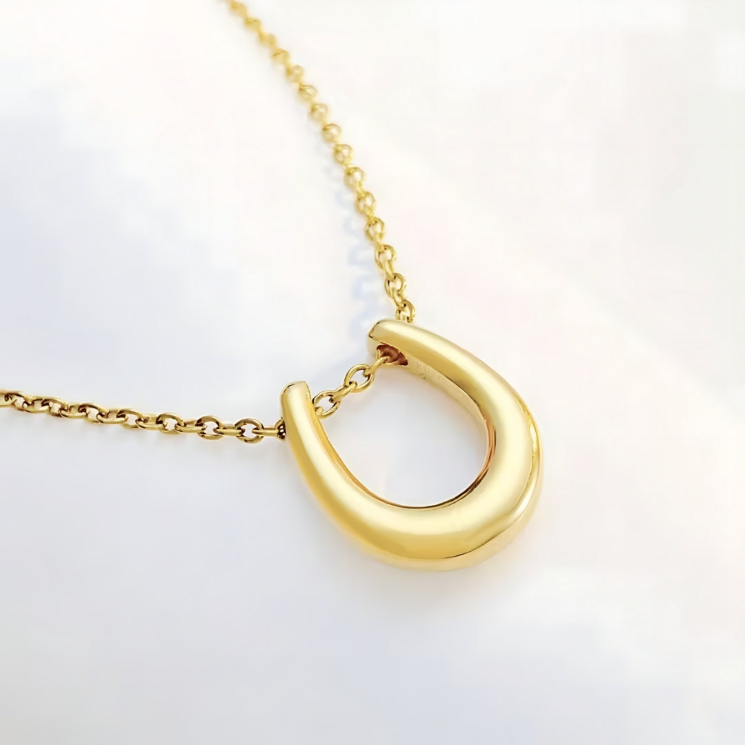 Aurea Horseshoe Necklace Perth Australia Houseofhide photographed in soft light revealing radiant golden tones and fine chain detail.