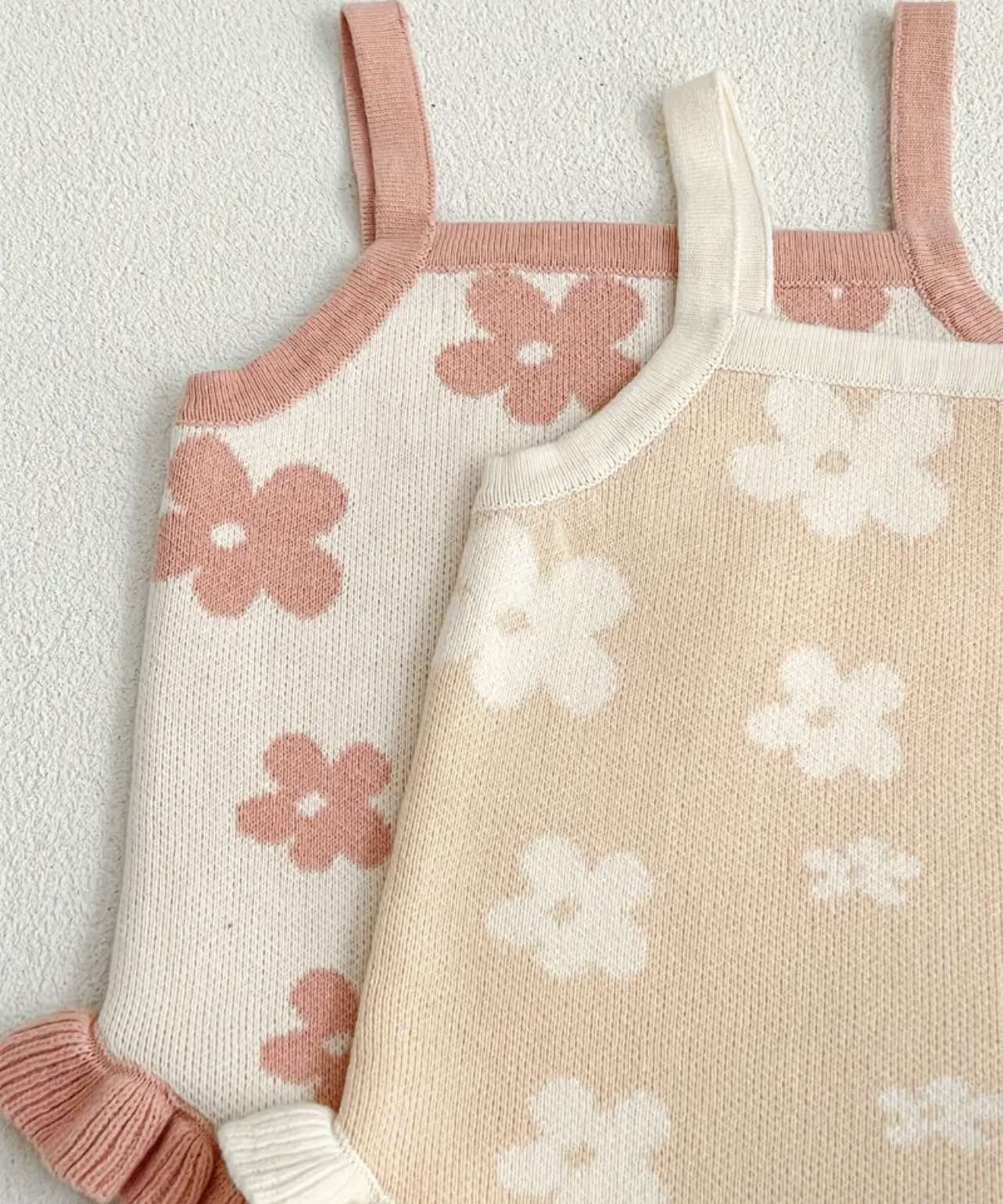 Baby girl wearing pink floral knitted romper, perfect for warm-weather comfort and style.