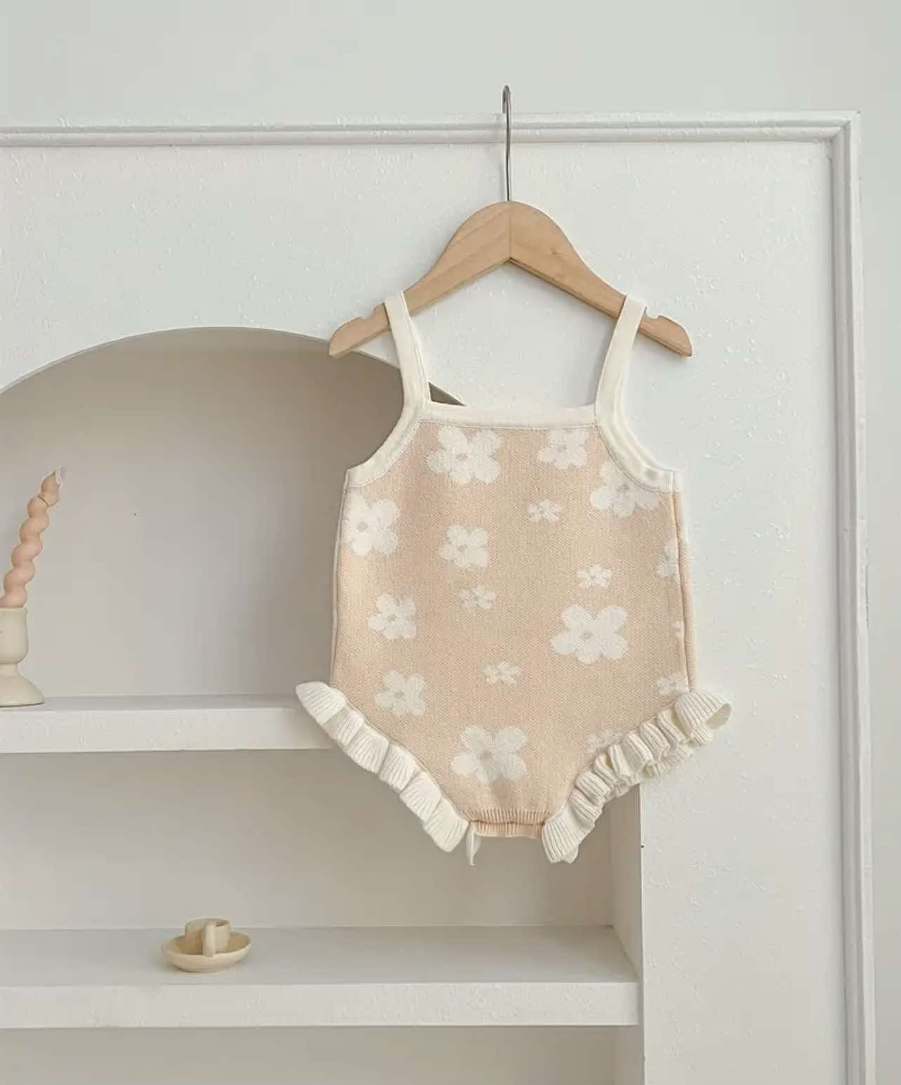 Back view of sleeveless beige floral romper for baby girls, showing strap details and floral design.