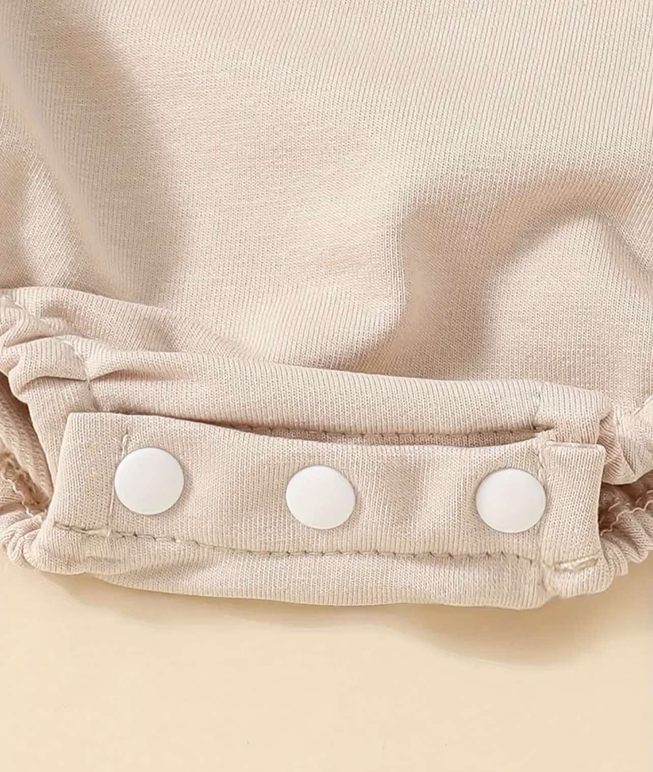 Beige long-sleeve baby onesie shown with three snap buttons at the bottom for easy diaper changes