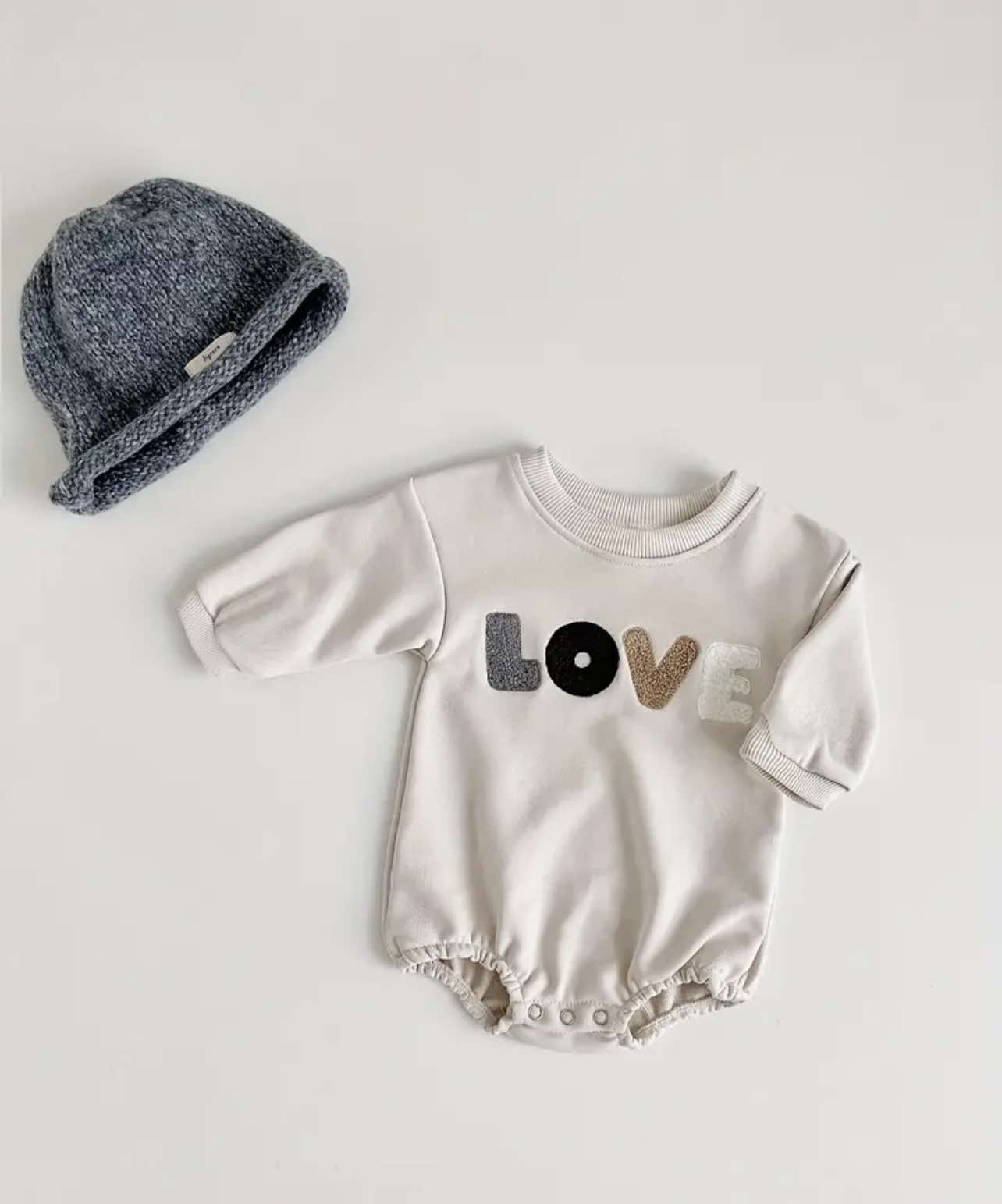 Close-up of the Love Romper Beige, featuring embroidered 'Love' text on soft cotton-polyester fabric—perfect for Australian babies.