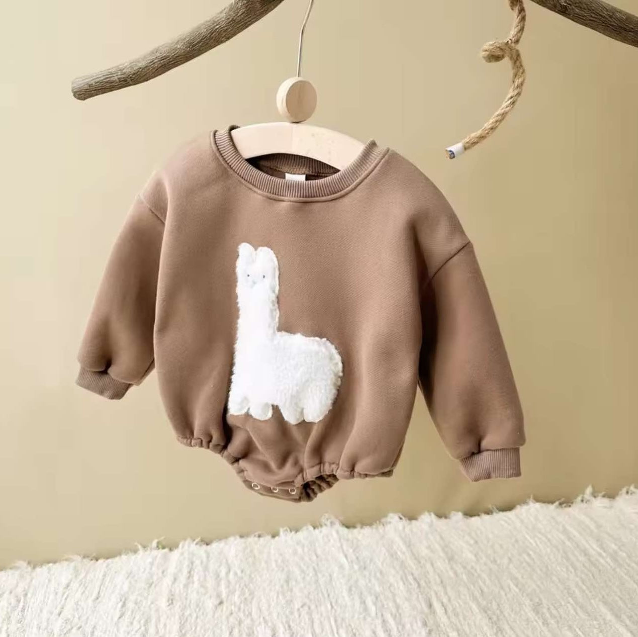 Gently gathered cuffs and waist give this fleece-lined baby romper a vintage, boho-country silhouette with adorable llama stitching.