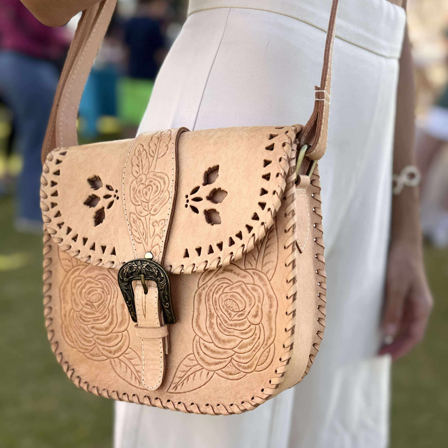 Woman wearing the Desert Rose hand-tooled leather saddle bag crossbody style – vintage-inspired Western handbag with floral detailing, styled for a relaxed country-boho look