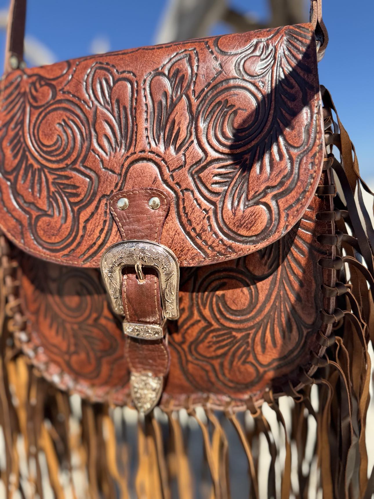 Feyre Fringe Leather Bag: House of Hide's brown leather crossbody with adjustable strap, tooled detailing, and flowing fringe.