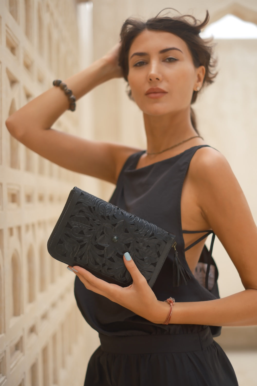 Genuine black leather wallet with intricate tooling, wrist strap, and multiple compartments for cards and cash.