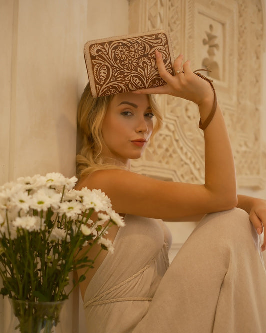 Genuine tan and cream leather wallet with wrist strap, floral tooling, and multiple compartments for cards and cash.