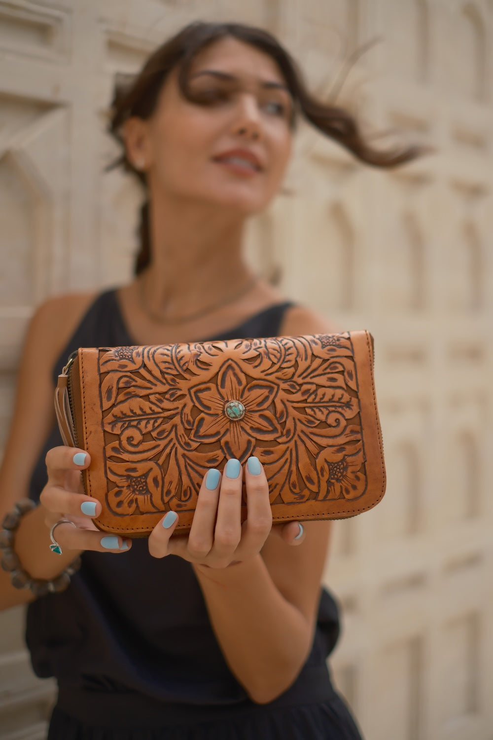 Hand‑carved tobacco leather wallet with zip closure, 20 card slots, stone detail, and detachable tassel. Ethically made, shipped Australia & worldwide.