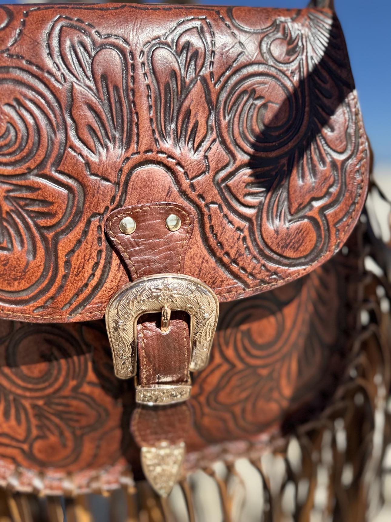 House of Hide Feyre Fringe Leather Bag: Close-up of the tooled brown leather with swirling floral and paisley designs.