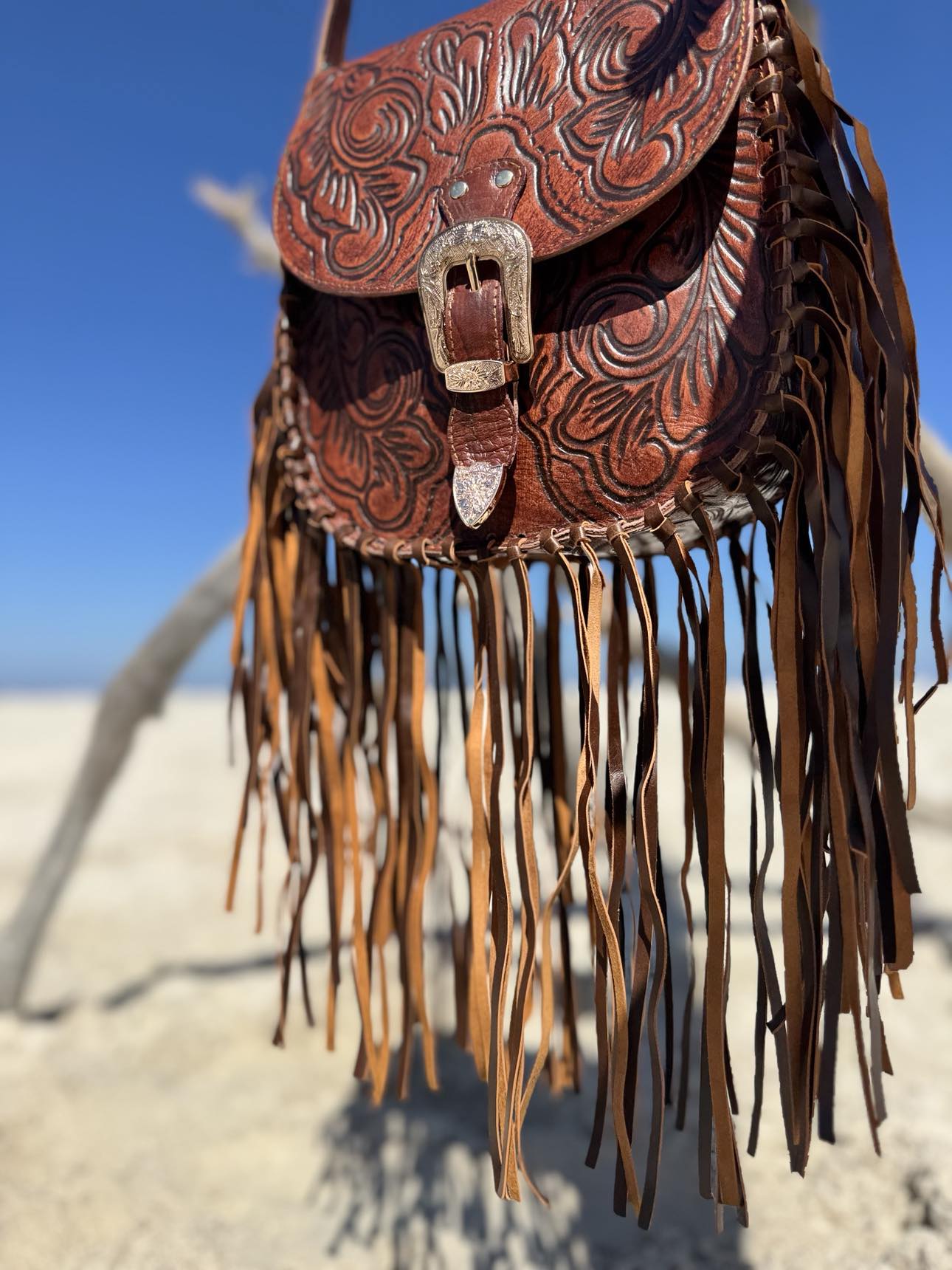 House of Hide Western Style Leather Bag: Detailed shot of the unique buckle closure with textured metal and fringe accents.