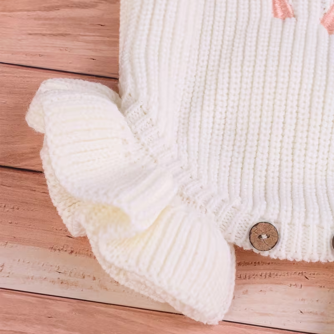 Little Darling Knit Romper Set from House of Hide in white ribbed knit baby romper and pink pom-pom beanie being styled in woven basket on blush wood flooring with newborn announcement aesthetic