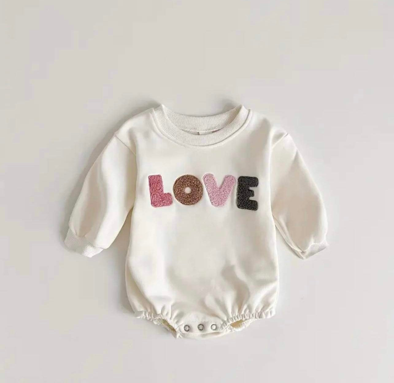 Long-sleeve pink romper with 'Love' embroidery for cooler days.