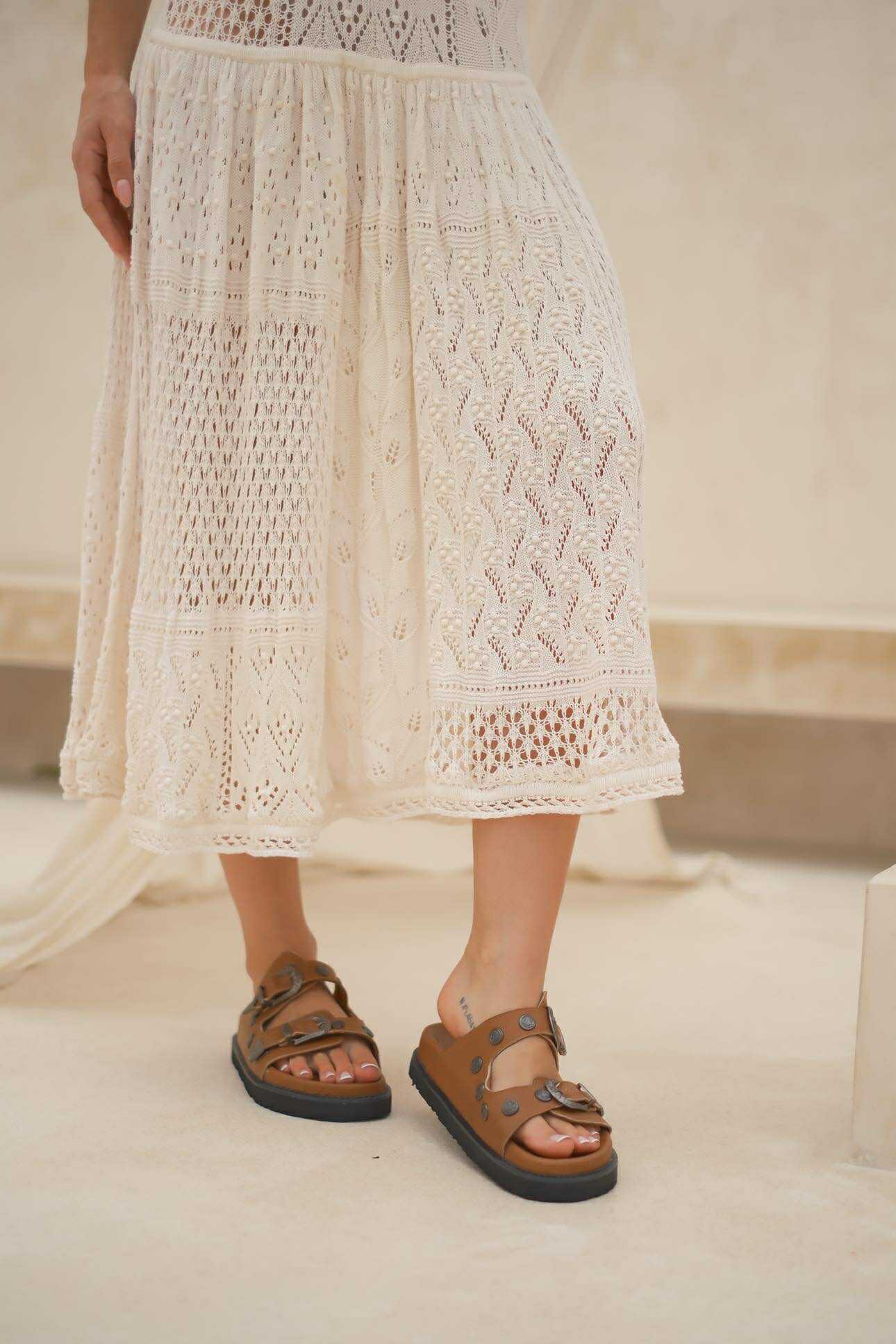Western-inspired brown sandals with wide straps and silver buckle—boho meets everyday comfort.