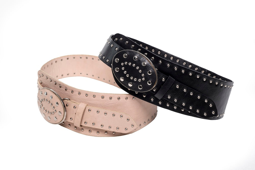 Handmade cream belt with oversized oval buckle laid on rustic timber