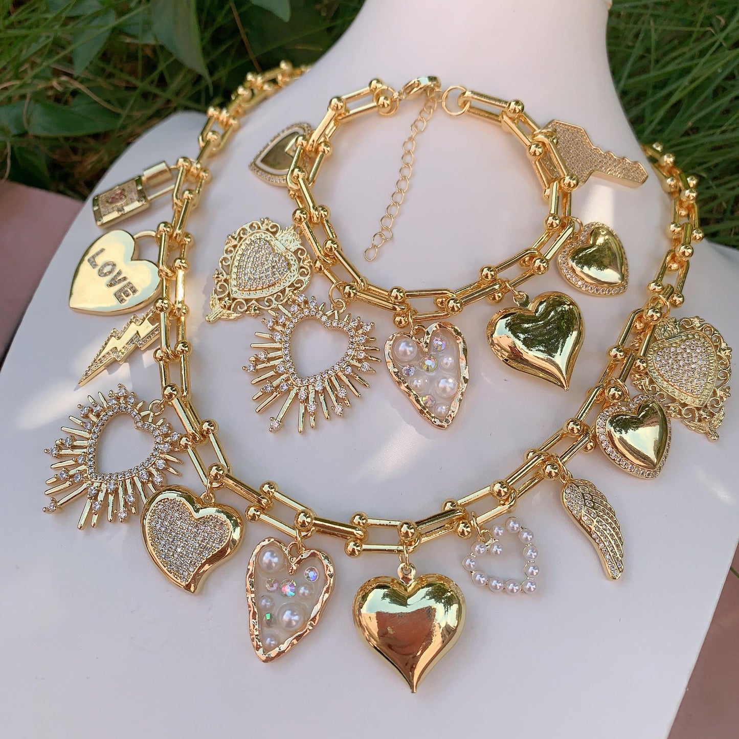 Gold necklace with various charms on a mannequin