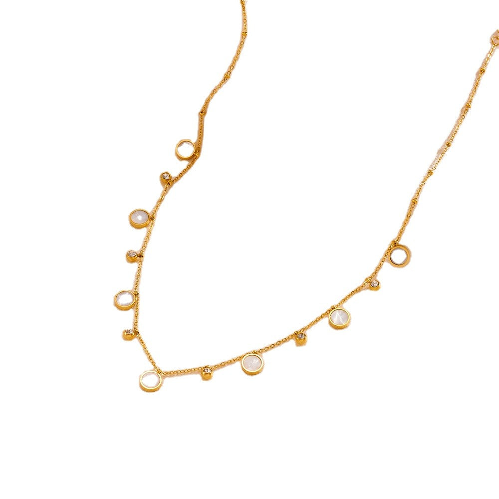 Gold necklace with small round pendants on a white background