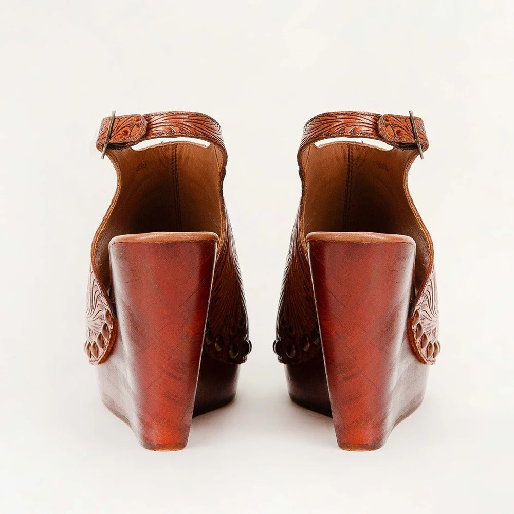 Amelia Sandals from House of Hide in brown leather with carved floral details on sides and chunky wedge heel being displayed from behind on white background