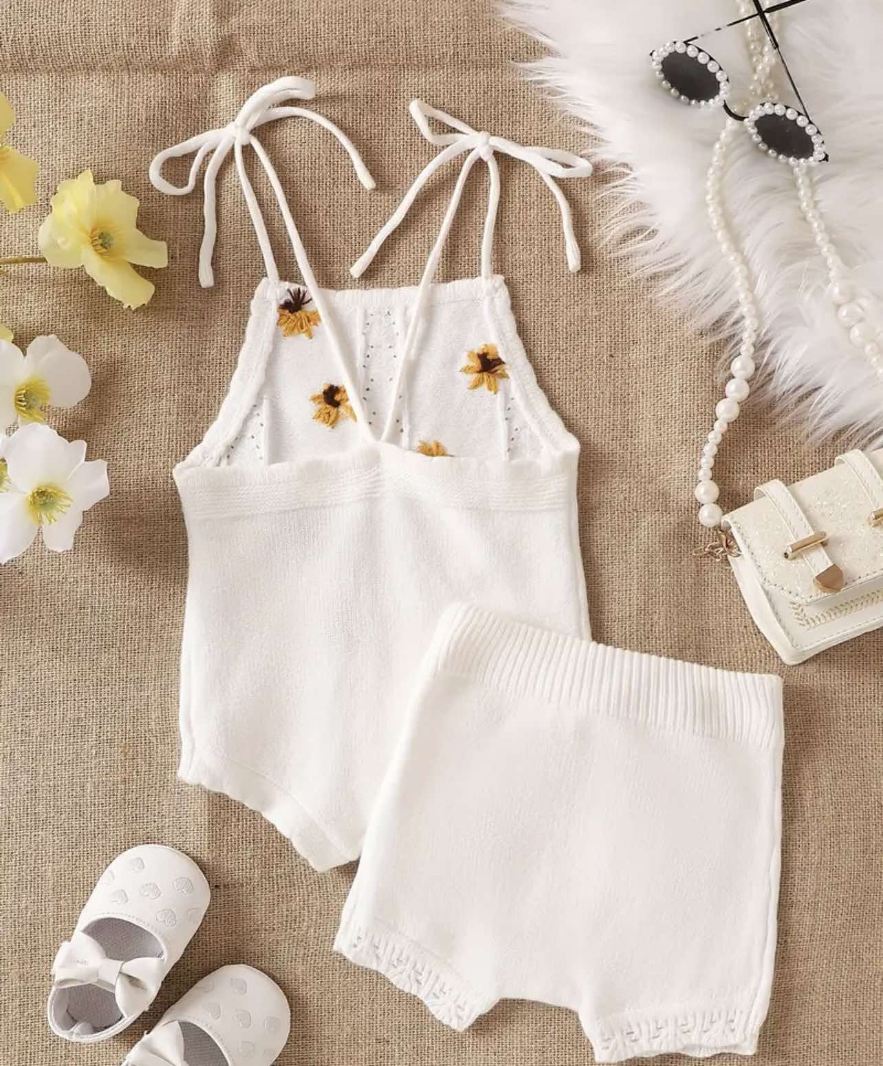 Baby wearing the White Sunflower Knit Two-Piece Set, featuring tie-strap tank top and matching white drawstring shorts.