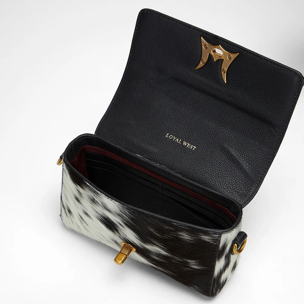 House of Hide genuine leather black handbag with cowhide pattern detailing and elegant gold accents on a white background