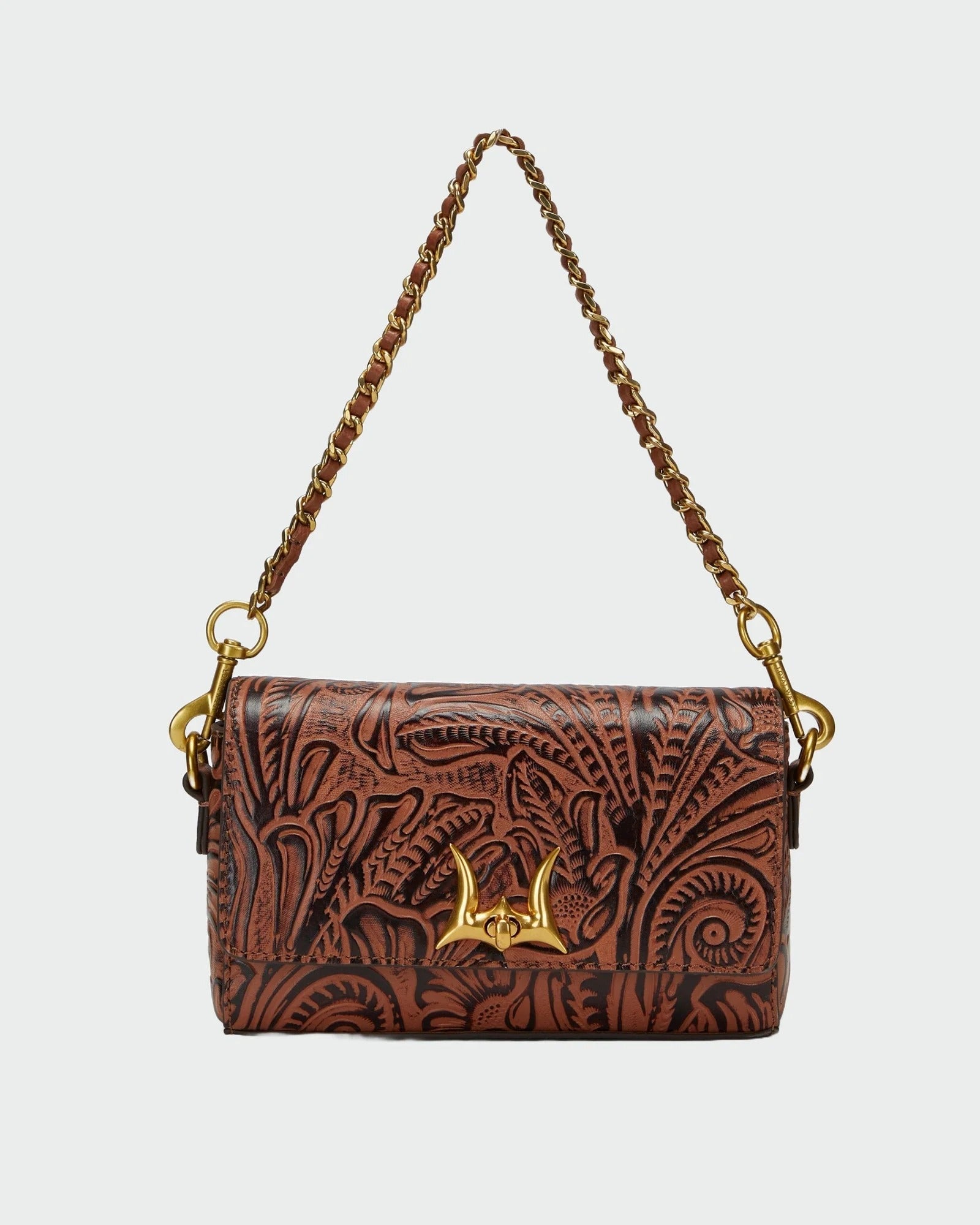 A brown tooled leather shoulder bag with an embossed floral pattern, a gold-tone chain strap, and a central gold-tone metal clasp, shown against a light gray background.