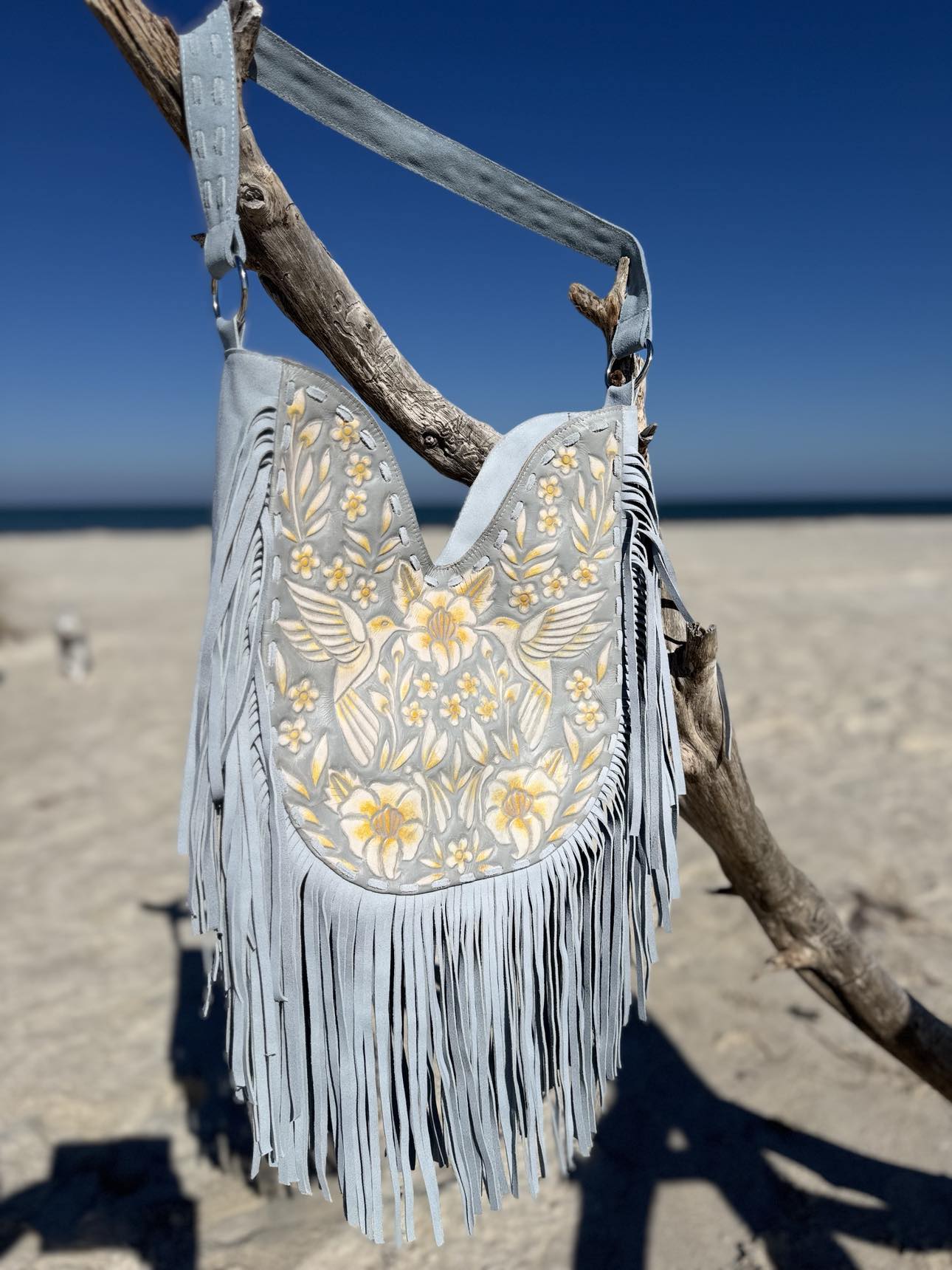 Blue Blossom Fringe Bag: light blue leather handbag with yellow floral accents and fringe tassels.