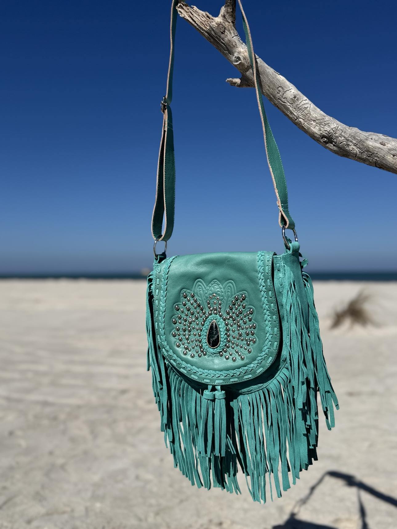 Boho-style turquoise leather bag with double-sided fringe and adjustable strap