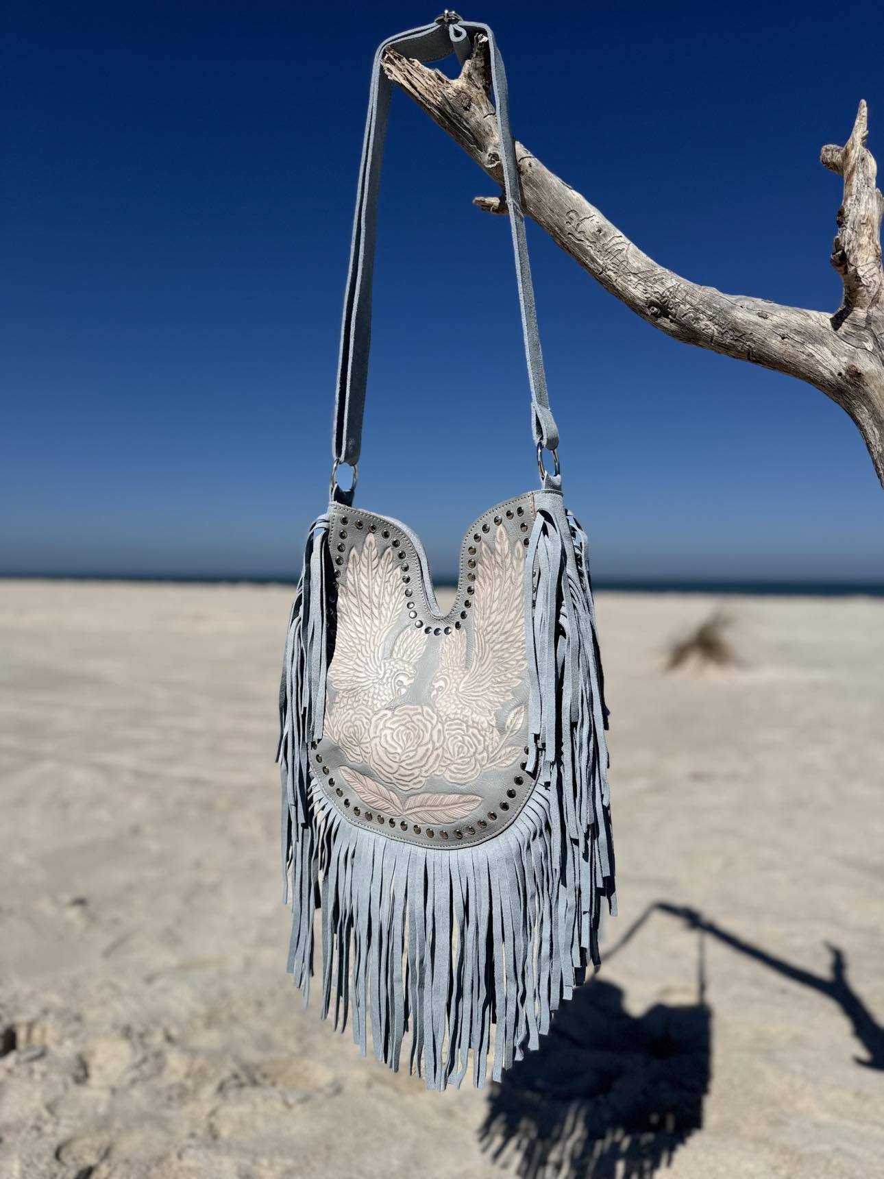 Boho fringe handbag with western-inspired saddle details for cool summer skin tones