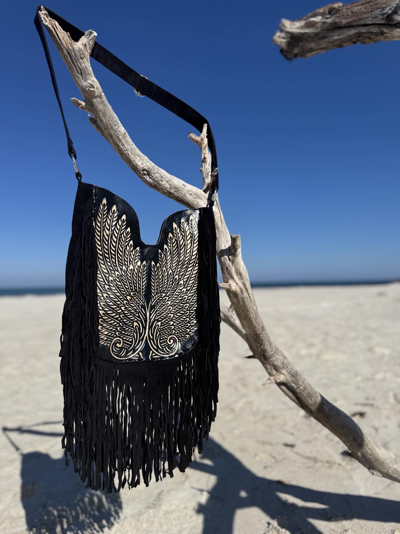 Boho leather crossbody bag featuring a handcrafted wing design in silver embroidery on metallic navy napa leather.