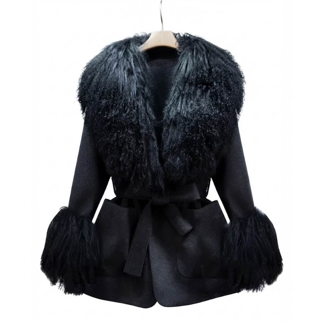 Cashmere Jacket from House of Hide in midnight black wool and cashmere blend with detachable Mongolian sheep fur collar and cuffs, adjustable tie belt for tailored silhouette, patch pockets, long loose trench silhouette being displayed on neutral background