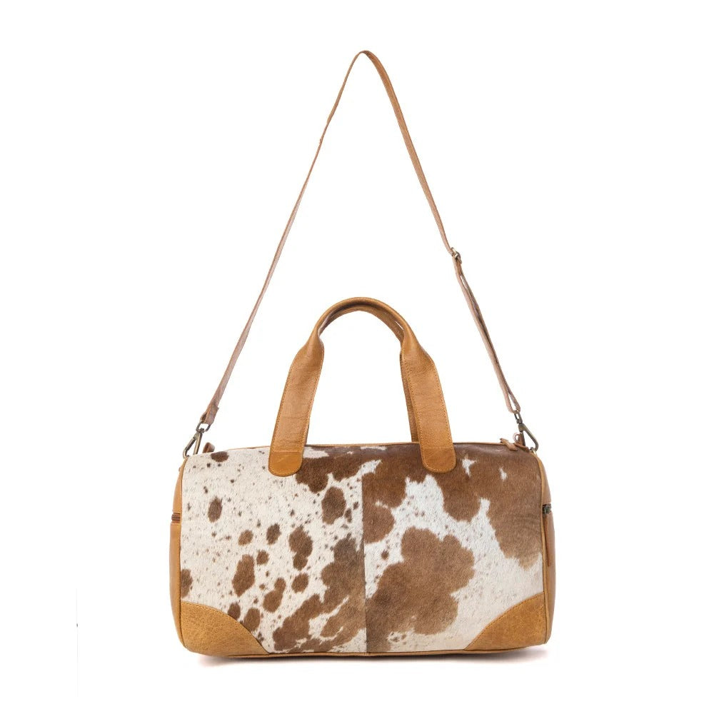House of Hide genuine leather brown and white cowhide patterned handbag with an adjustable shoulder strap on a white background