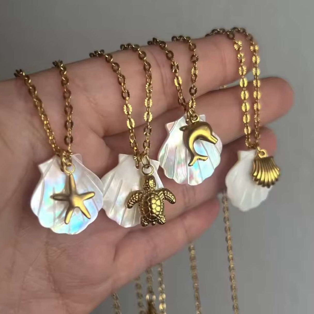 Channel beach vibes with this Summer Beach Charm Necklace! Featuring starfish, seashells, and sea turtles, this waterproof surfer necklace brings ocean-inspired elegance to any outfit.