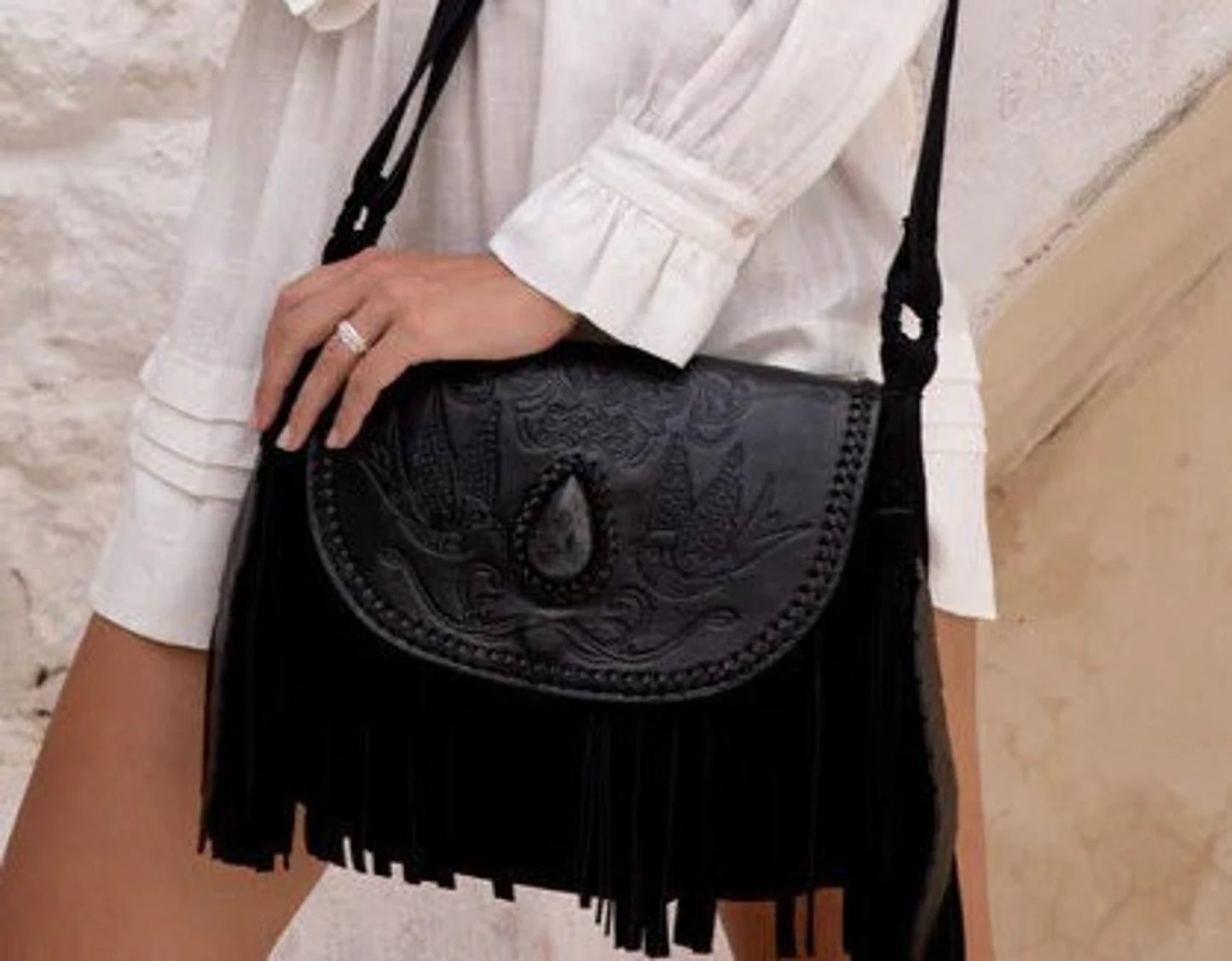 Close-up of Raven Bag’s hand-painted leather flap with labradorite gemstone and hand-tooled swallow design.