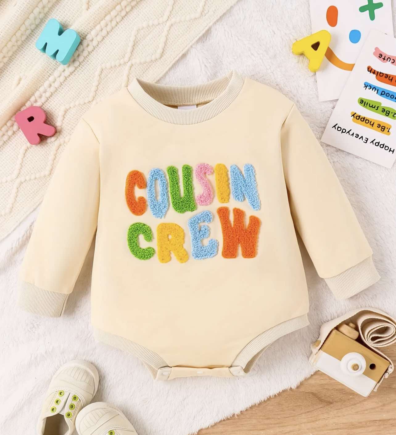 Close-up of colorful "COUSIN CREW" embroidered lettering on a toddler sweatshirt.