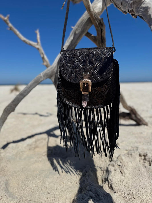 Close-up view of the Blackstone Crossbody showcasing intricate hand-tooled details and flowing leather tassels.