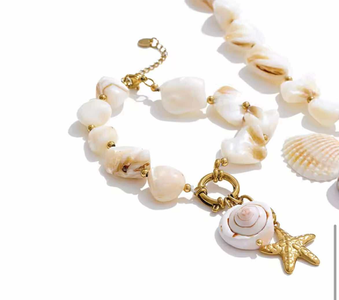 Coastal-style stretch bracelet featuring baroque pearls and scallop shell pendant