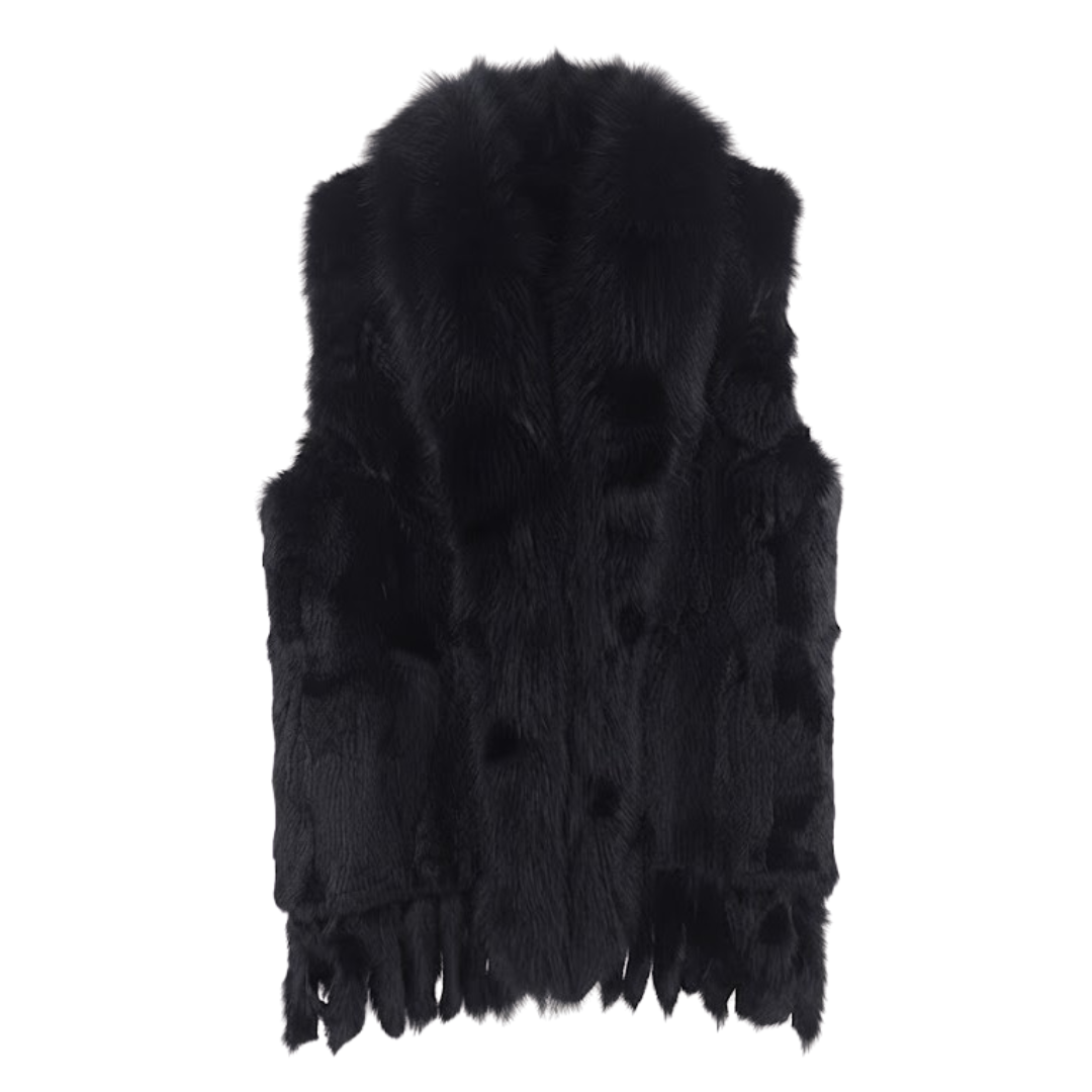 Cottontail Fur Vest from House of Hide in 100% real black rabbit fur with plush raccoon fur collar, fringed hem detail, single button closure, sleeveless silhouette being displayed on neutral background as versatile layering piece for winter styling