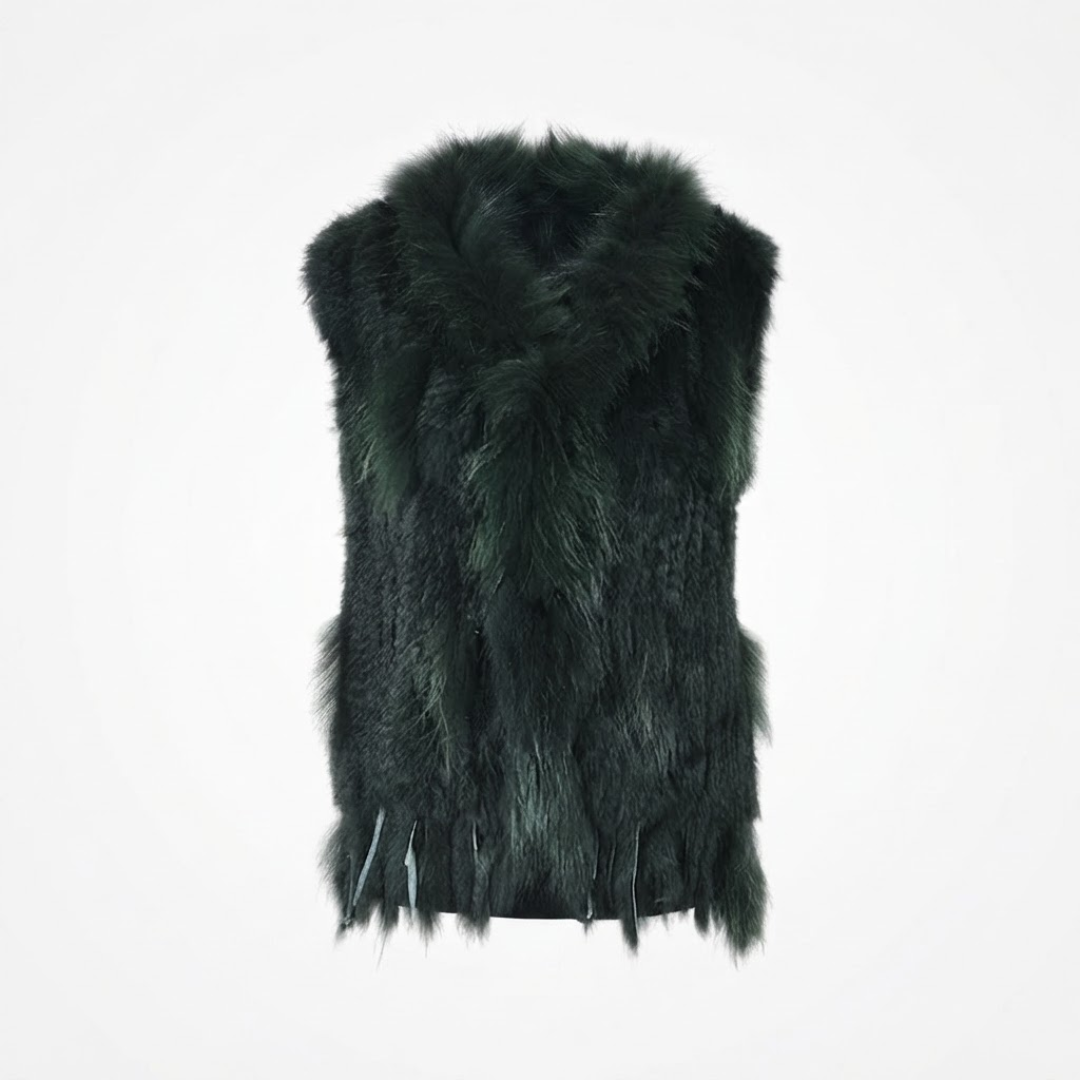 Cottontail Fur Vest from House of Hide in bold deep forest green real rabbit fur with plush raccoon fur collar, fringed hem detail, single button closure, sleeveless silhouette being displayed on neutral background as versatile layering piece for winter styling