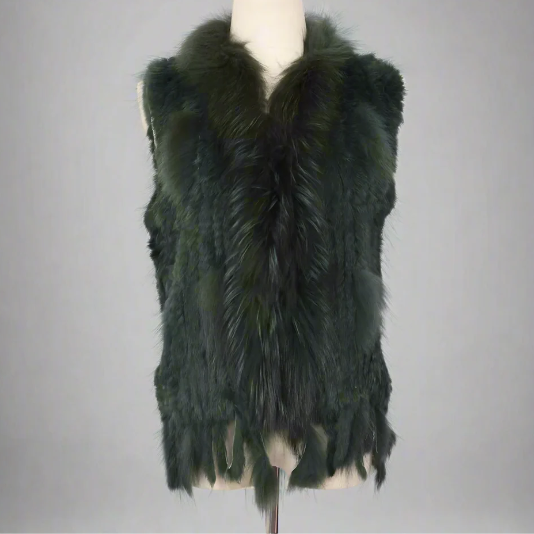 Cottontail Fur Vest from House of Hide in deep forest green real rabbit fur with luxe plush raccoon fur collar accent, fringed moving hem, single button front closure, sleeveless knitted construction designed to layer over jumpers, dresses or any outfit for bold edge warmth without bulk