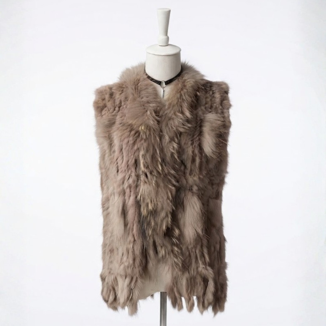 Cottontail Fur Vest from House of Hide in earthy khaki real rabbit fur with luxe plush raccoon fur collar accent, fringed moving hem, single button front closure, sleeveless knitted construction designed to layer over jumpers, dresses or any outfit for bold edge warmth without bulk
