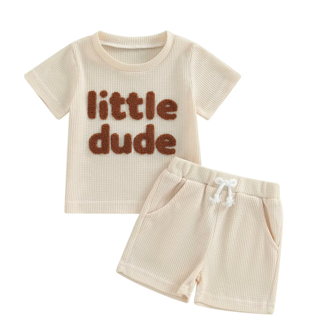 Soft cream top and shorts set with playful embroidery, styled for sunny days and warm-weather adventures.