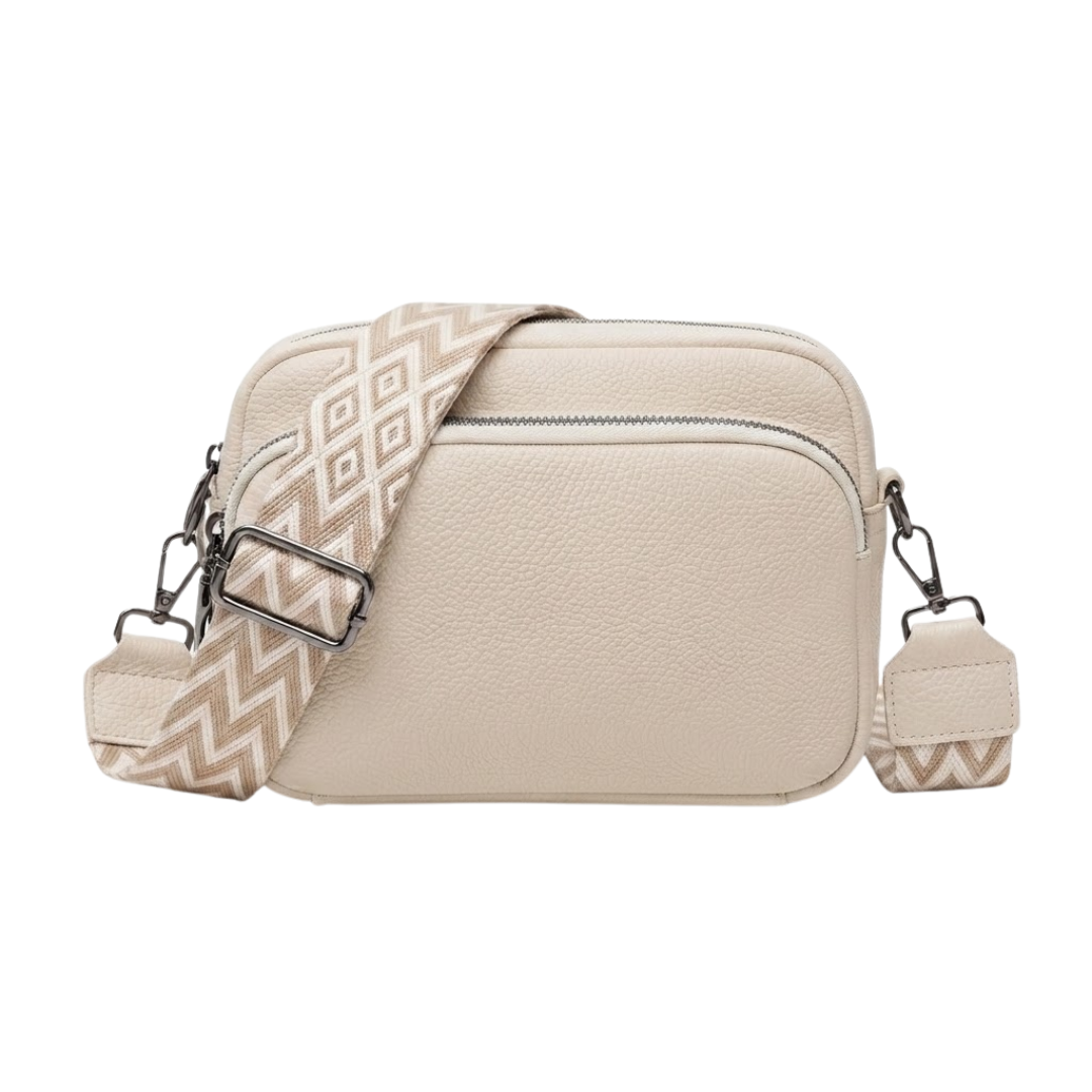 A cream-colored pebbled faux-leather crossbody bag with a patterned beige and cream woven strap, shown against a plain white background.