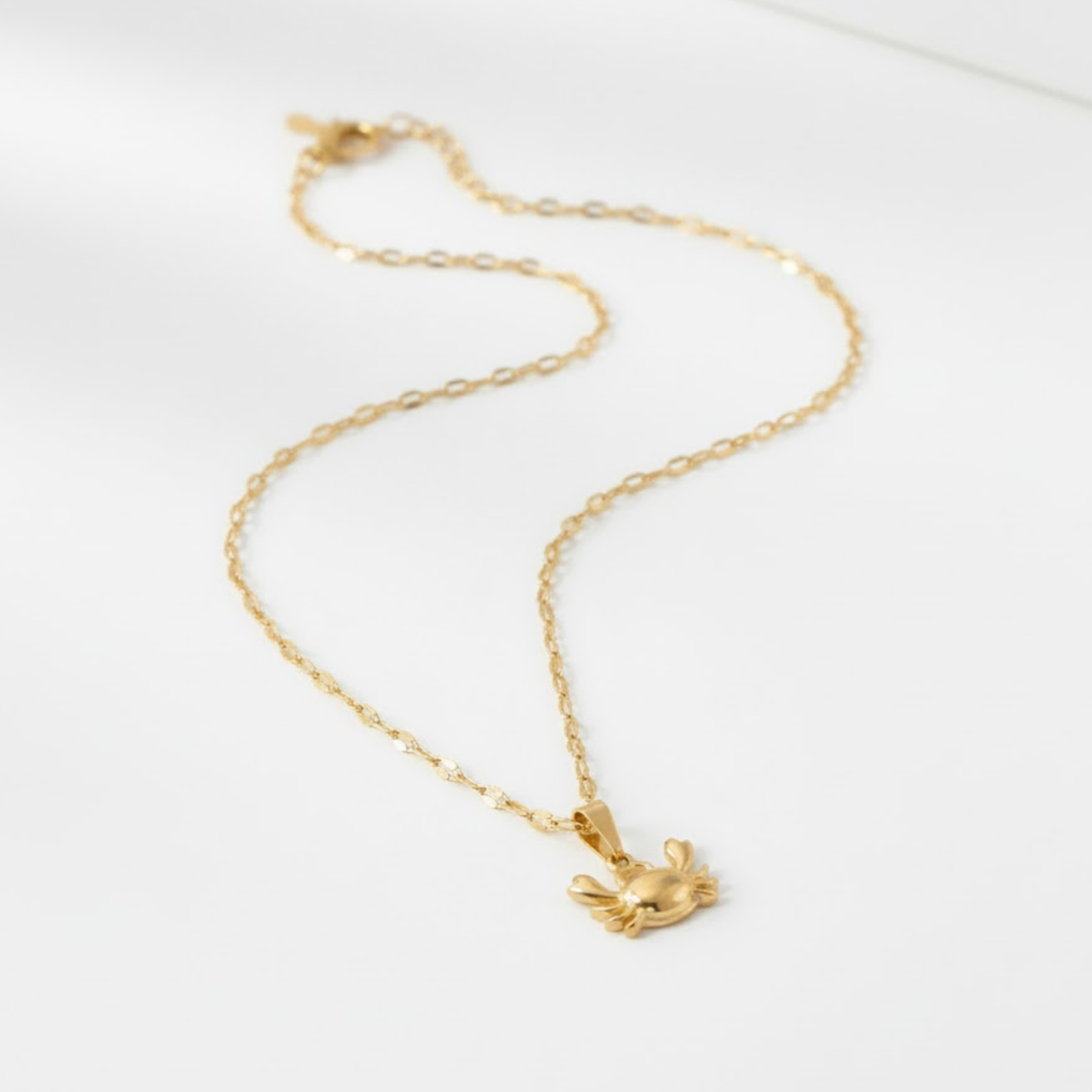 Gold-plated CrystaCrab Necklace with glossy crab pendant symbolising the carefree spirit of the sea.
