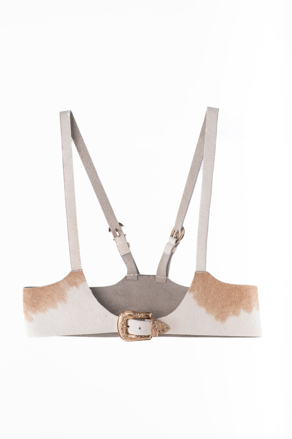 Custom-made cowhide harness featuring natural hide patterns and adjustable straps.