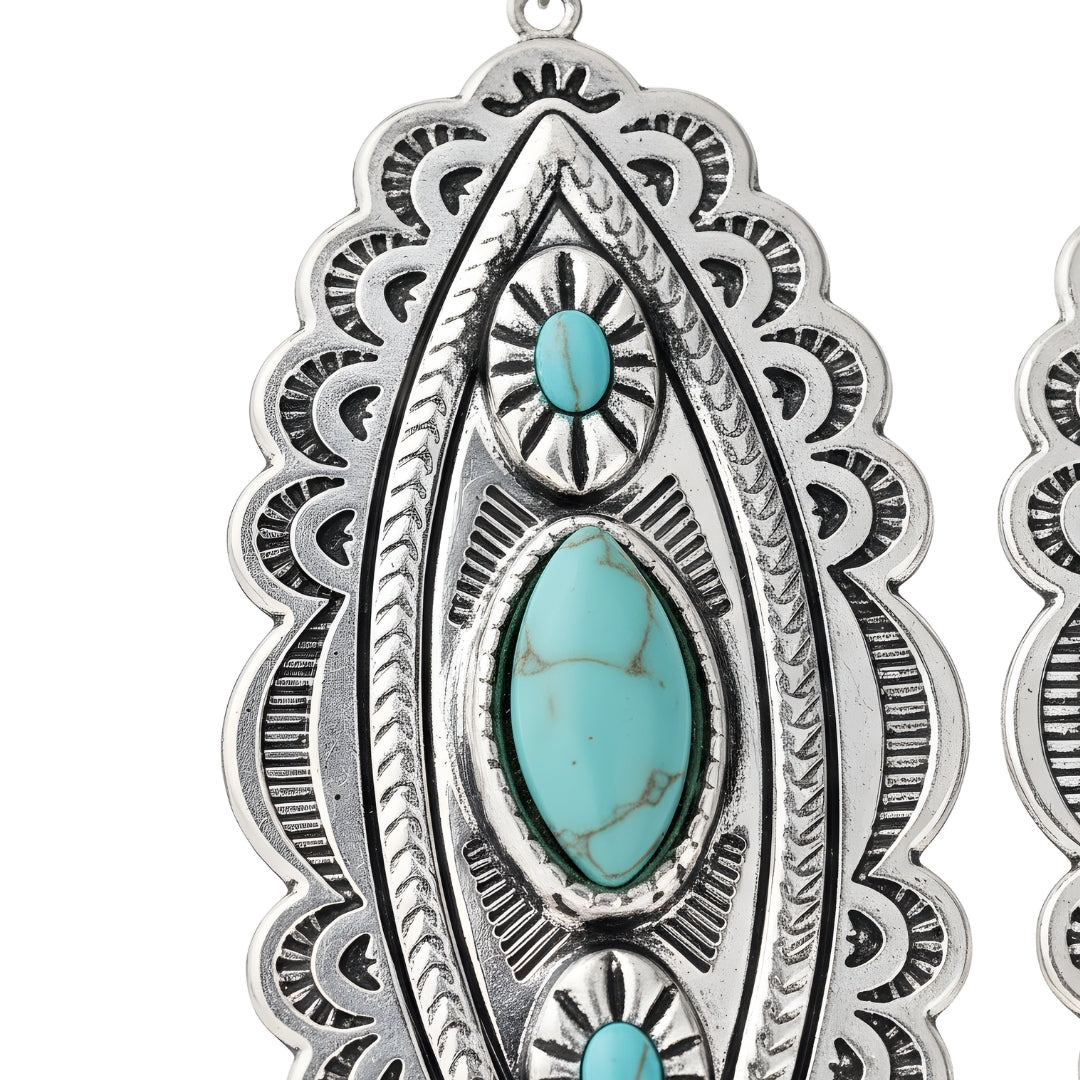 Pair of turquoise and silver earrings by House of Hide Perth displayed on white surface