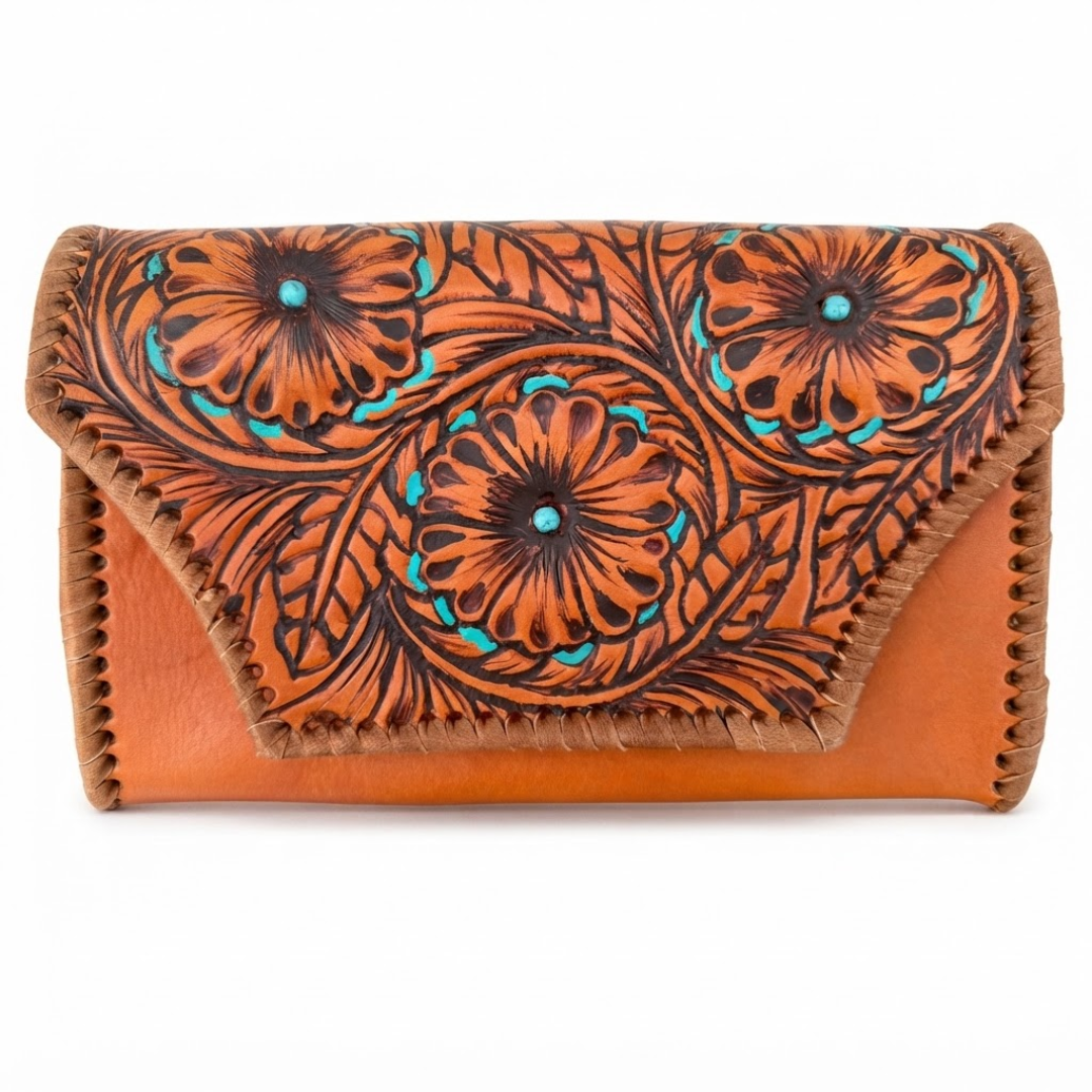 A tooled leather clutch wallet in a warm tan-brown color, featuring a flap decorated with dark brown floral tooling and turquoise accents, set against a plain white background.