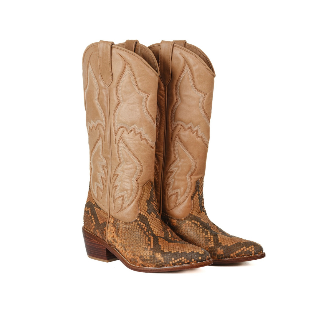 A pair of cowboy boots featuring tan leather shafts with western-style stitching and a brown and tan snakeskin-patterned lower section and foot, shown against a plain white background.