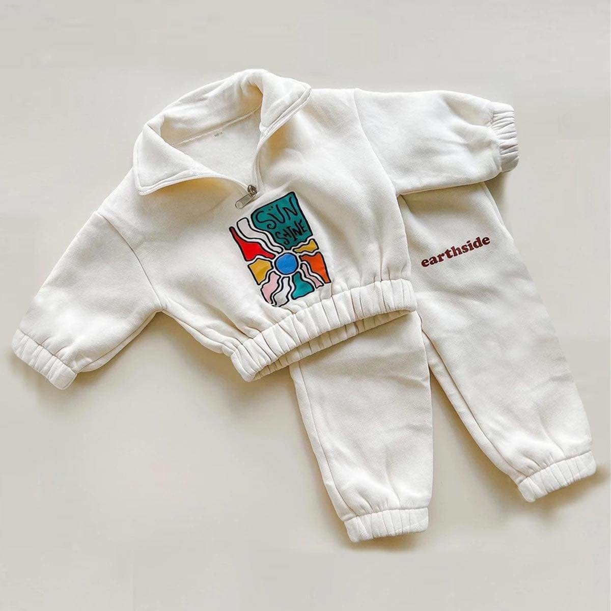 Trendy white Earthside Tracksuit Set with a retro print, thick fleece lining, and soft cotton fabric for warmth and comfort.