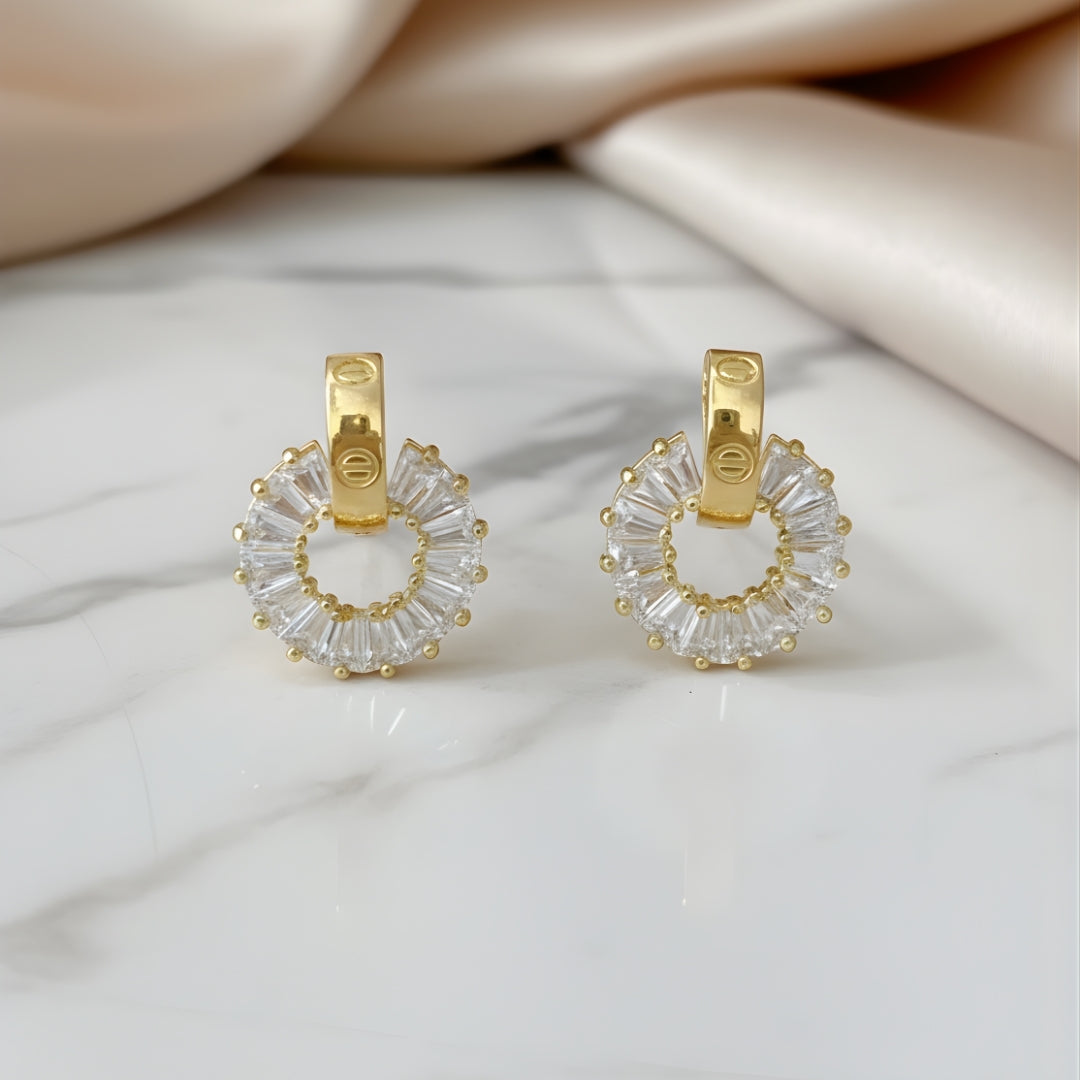 Eternal Halo Earrings with gold hoops and sparkling clear gems on white surface