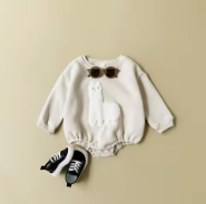 Cosy cream romper with a stitched llama motif, styled for little ones on winter adventures.